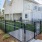 a fenced in green lawn in front of a building