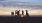 A group of friends hanging out on the beach at sunset	